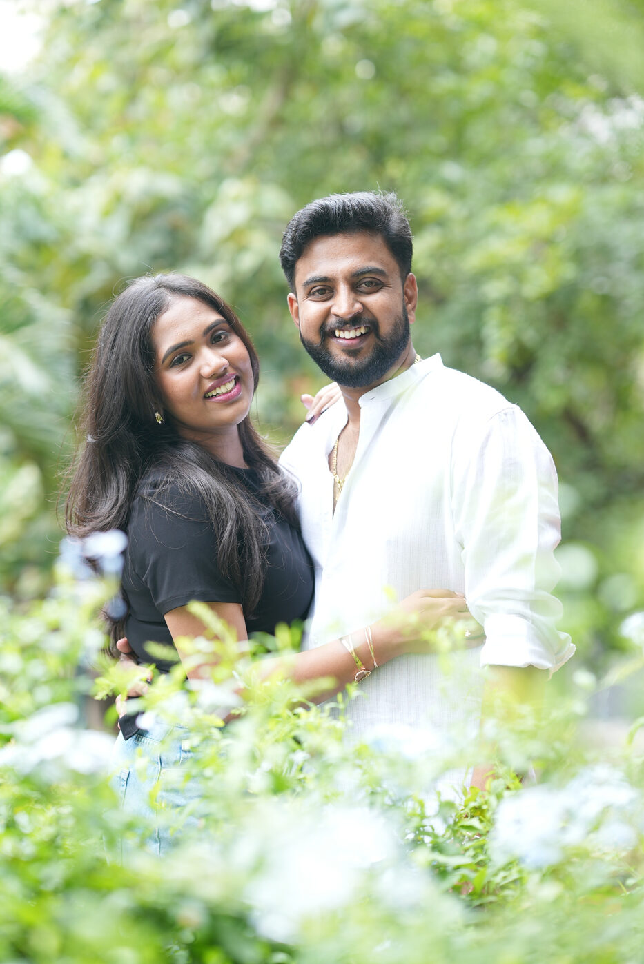 Navya and Subramanya laughing together among garden flowers