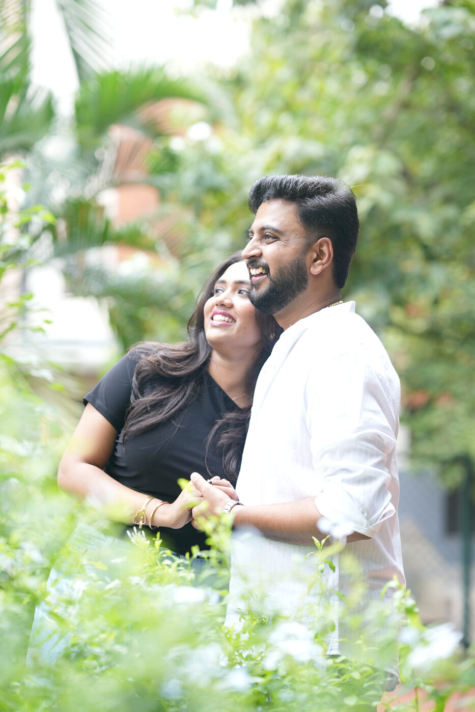 Navya and Subramanya hugging and laughing in a garden