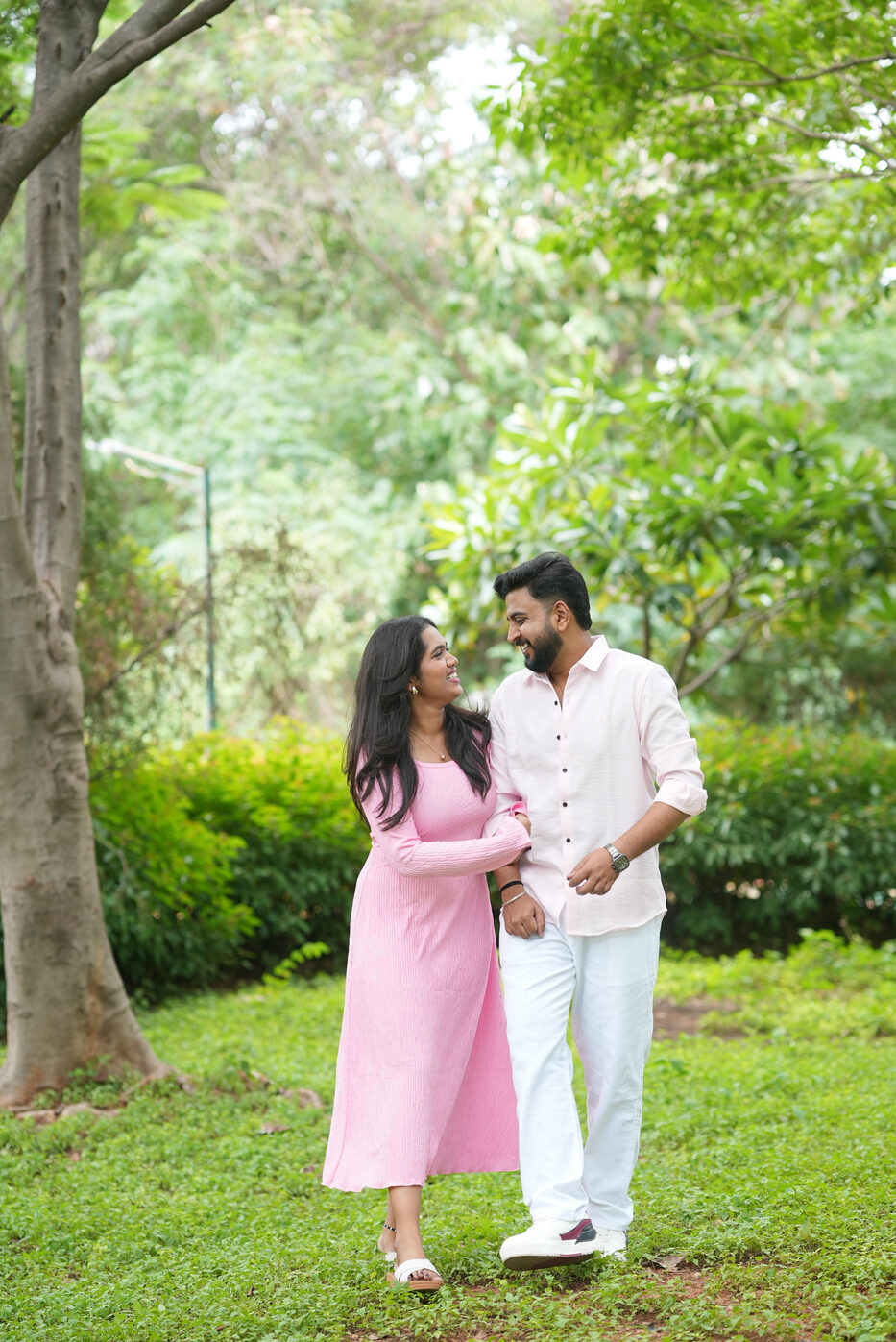 Navya in a pink dress with Subramanya under a garden tree